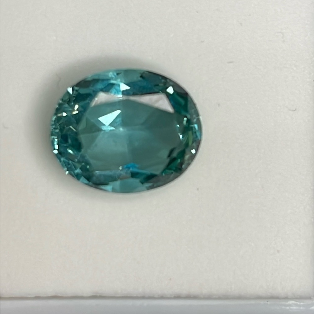 4.80ct 11x9mm oval treated Teal Topaz.​​